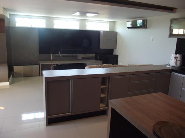 Sala de TV com espaço com churrasqueira e terraço.